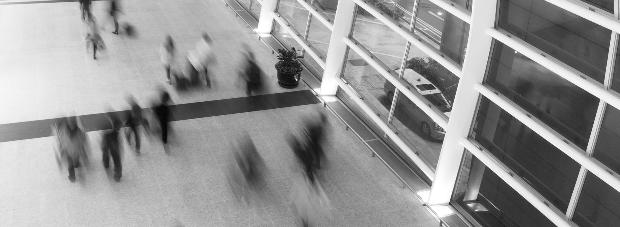 Una foto en blanco y negro de personas caminando en un aeropuerto
